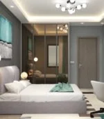 VR360 PAKETİ'nin yer aldığı modern bir yatak odasında zarif villa unsurları sergileniyor: gri bir yatak, aynalı gardırop, beyaz ofis koltuğu ve soyut bir tabloya sıcaklık veren bir tavan lambası. Şık kurulum, aynadaki aile köpeğini ustaca yansıtıyor.